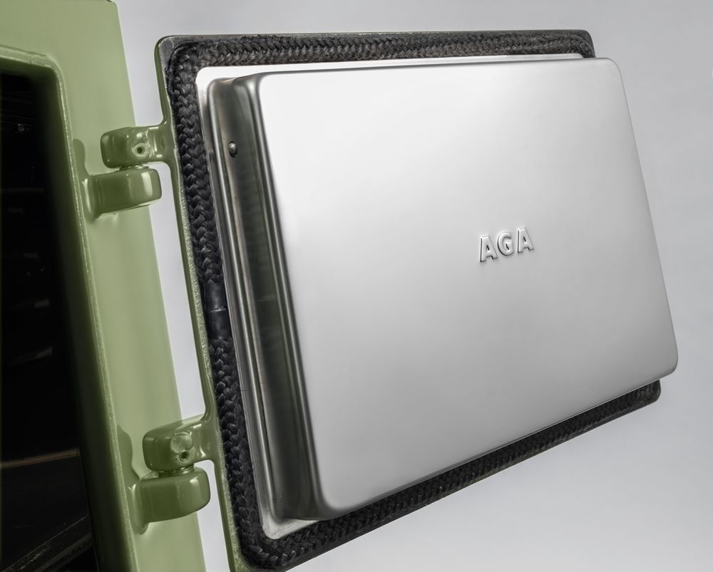 Porte de four ouverte d’une AGA Classic émail Olivine, doublure inox frappée AGA
