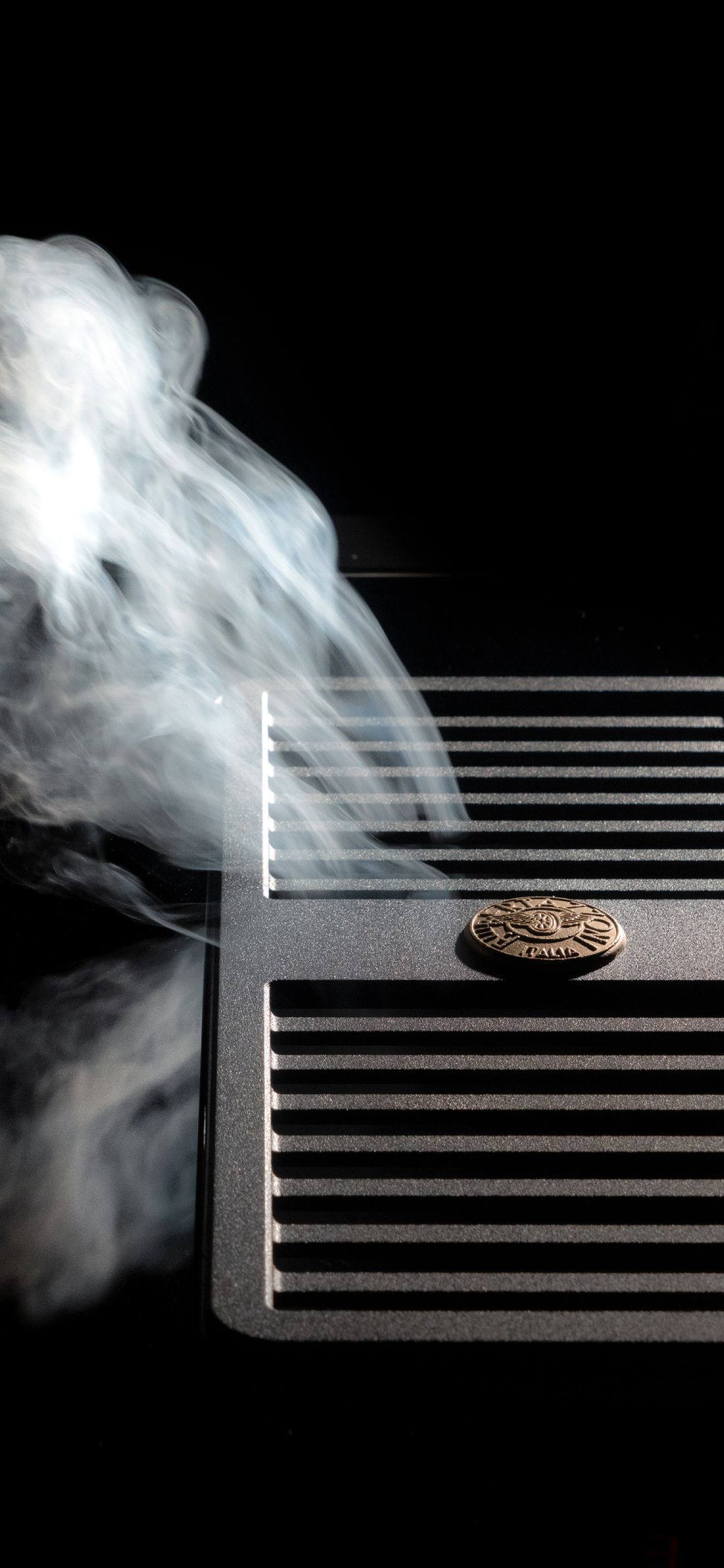Vapeur aspirée par la grille d’une table induction Bertazzoni à hotte intégrée