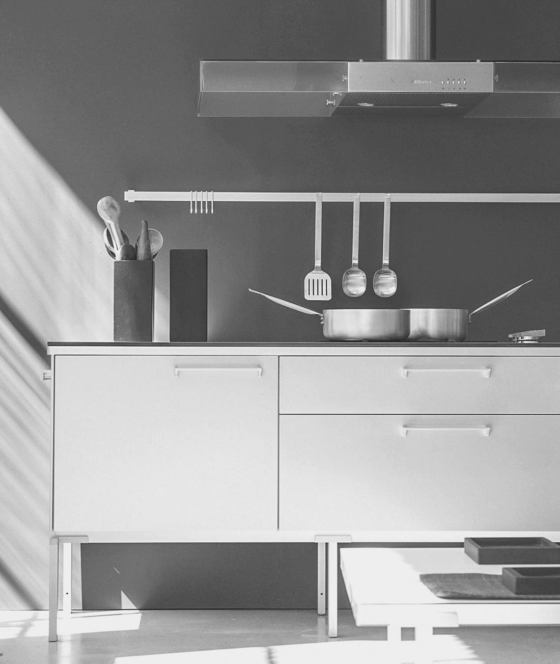 Photo d’archive en noir et blanc de la cuisine Binova Regula, meubles suspendus sur pieds