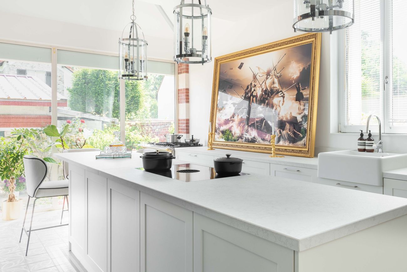 Îlot blanc équipé d’une table BORA dans la cuisine lumineuse d’une maison française, tableau à cadre doré
