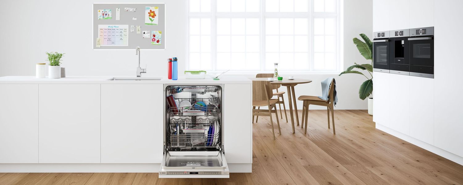Lave-vaisselle Bosch tout intégrable ouvert dans une cuisine blanche