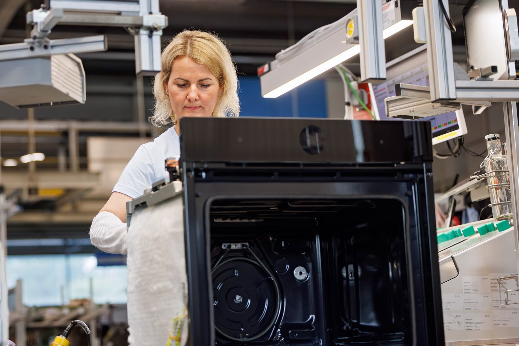 Opératrice assemblant un four encastrable sur la ligne de l’usine BSH de Traunreut