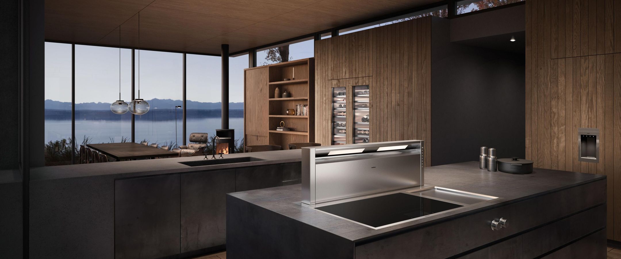 Îlot avec tables de cuisson Vario Gaggenau et hotte de plan de travail, cuisine bois face à un lac