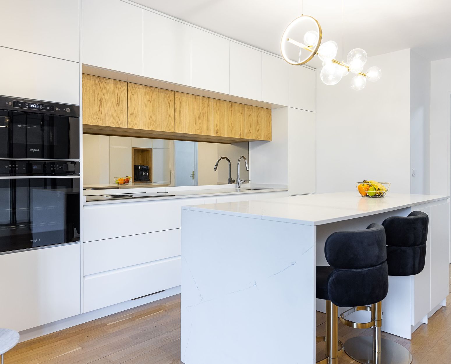Cuisine blanche sur mesure avec îlot effet marbre et tabourets en velours noir