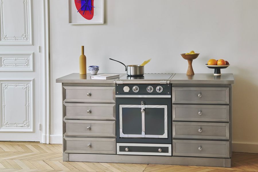 Piano La Cornue Castel 60 intégré entre deux meubles inox dans un appartement à moulures et parquet