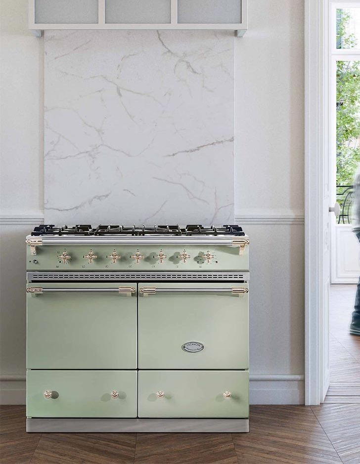 Piano de cuisson Lacanche vert amande à deux fours, crédence en marbre, dans un appartement parisien