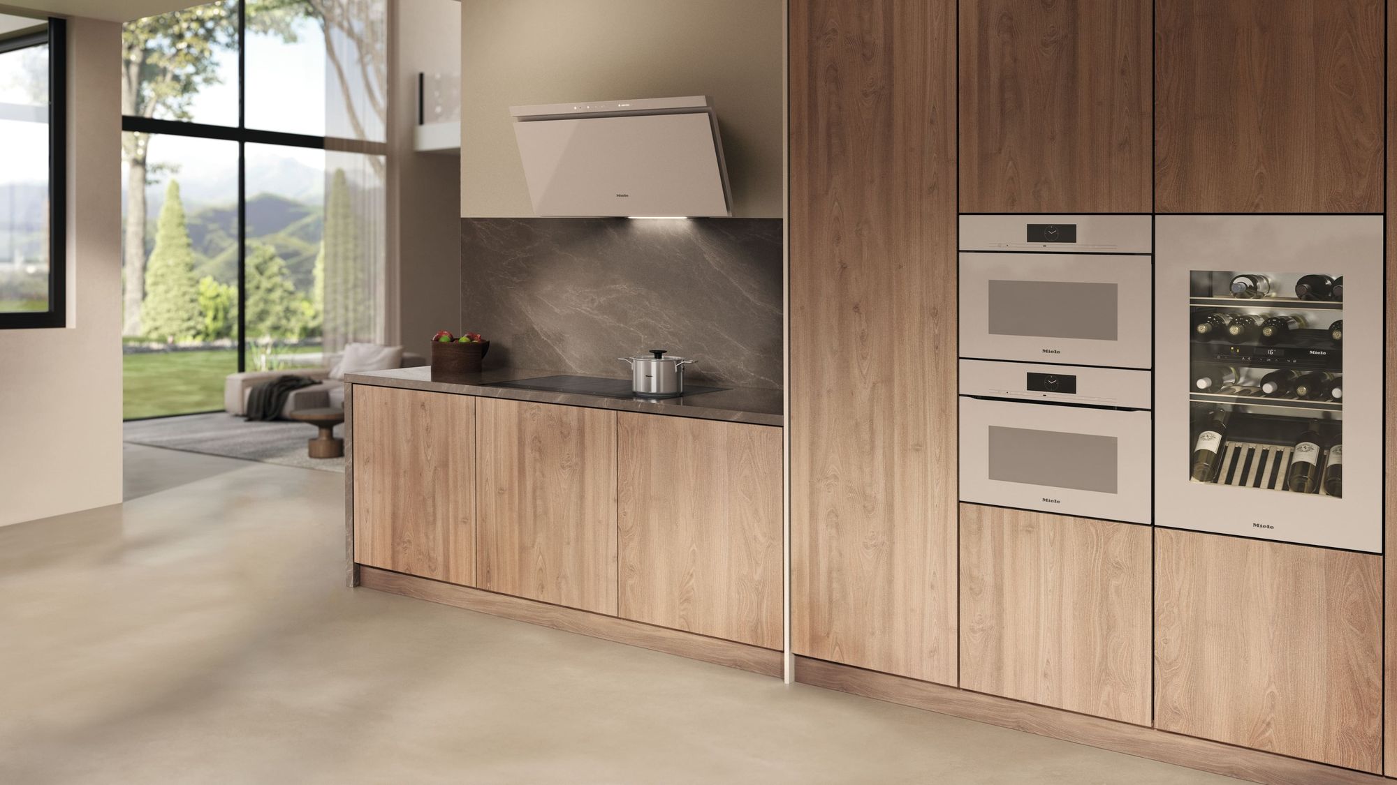 Cuisine en bois clair équipée d’appareils Miele coloris Pearlbeige : fours en colonne, cave à vin et hotte murale