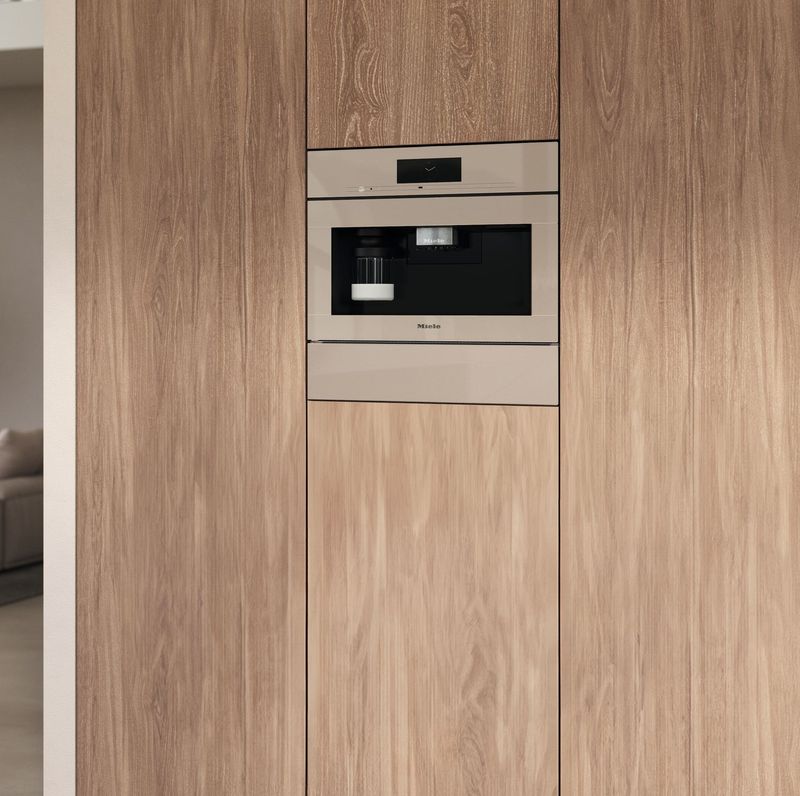 Machine à café encastrable Miele coloris Pearlbeige dans une colonne en bois clair