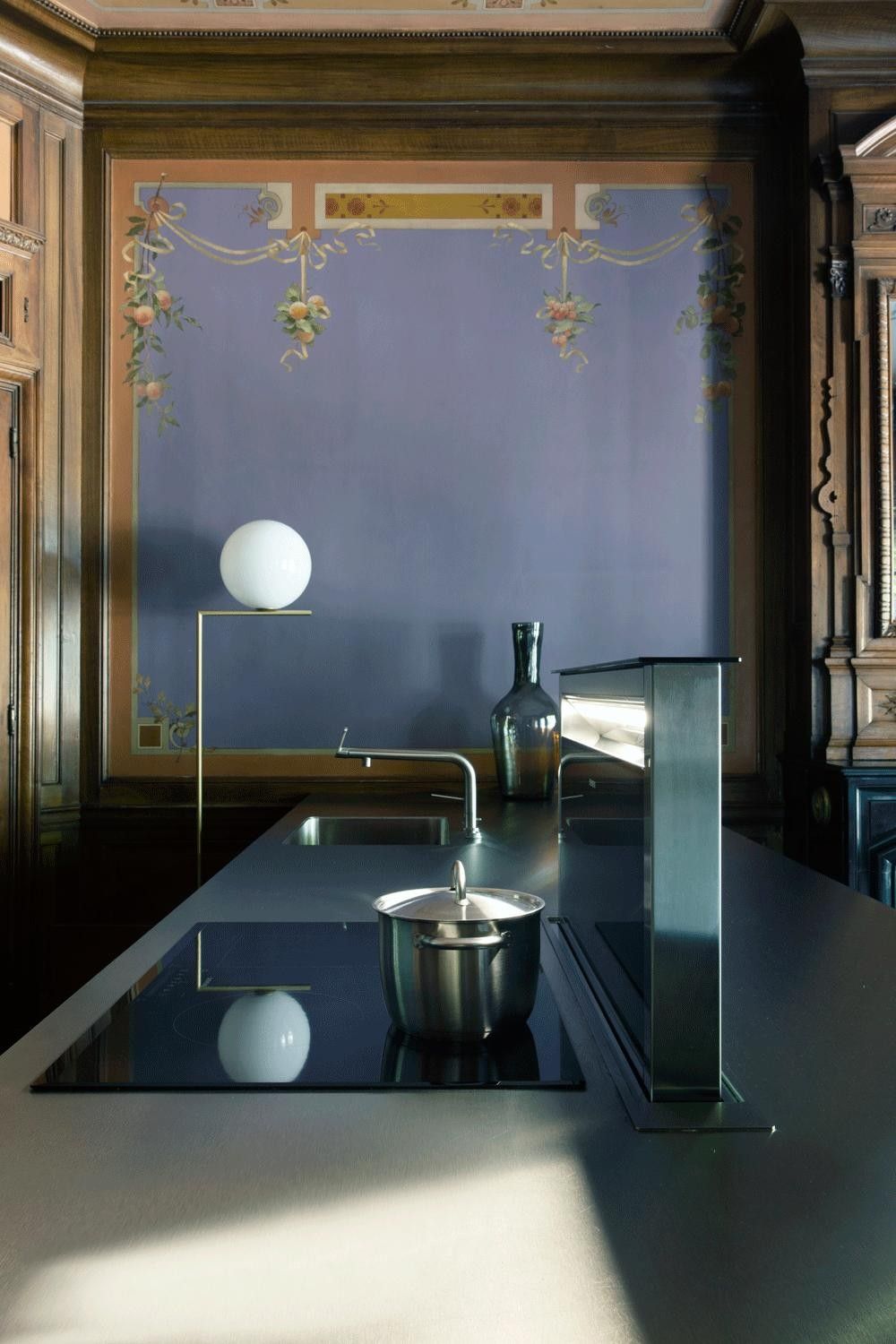 Îlot avec table induction et hotte escamotable downdraftAir Siemens dans un salon à boiseries