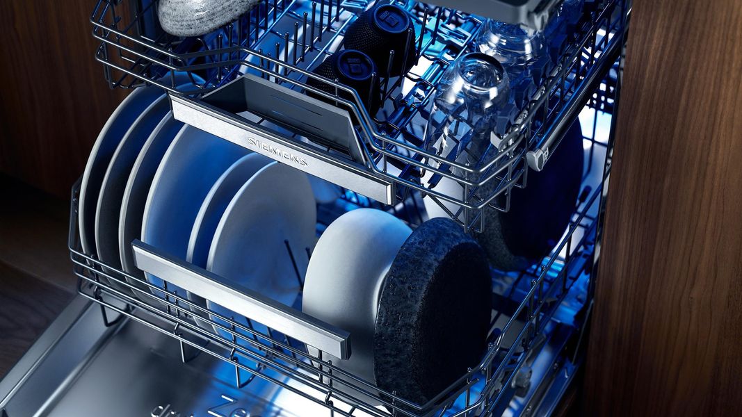 Lave-vaisselle Siemens iQ700 ouvert, paniers chargés, éclairage intérieur bleu