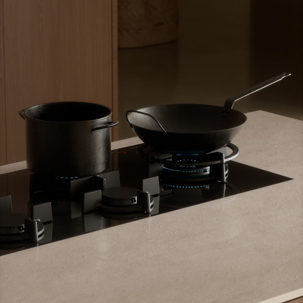 Table de cuisson gaz V-ZUG à brûleur wok, faitout et wok noirs sur un plan en pierre claire